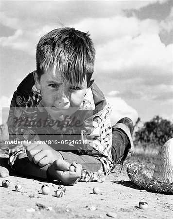 1950s BOY SHOOTING MARBLES OUTDOOR
