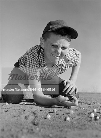 1950s - 1960s BOY PLAYING MARBLES KNEELING IN THE DIRT SQUINTING MISSING A FRONT TOOTH