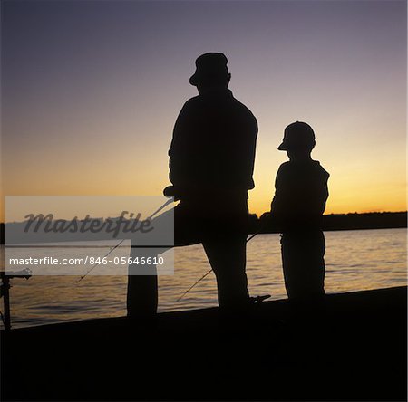 FATHER SON SILHOUETTED SUNSET LAKESIDE FISHING