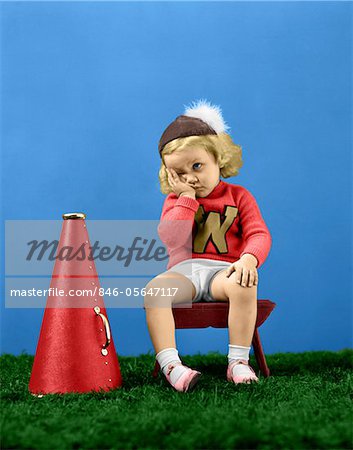 1940s UNHAPPY FRUSTRATED SAD LITTLE GIRL CHEERLEADER WEARING A CAP VARSITY SPORTS SWEATER