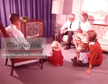 1960s THREE GENERATION FAMILY WATCHING TELEVISION  IN LIVING ROOM