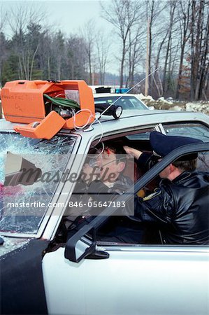 POLICE OFFICER ADMINISTERING OXYGEN TO ACCIDENT VICTIM