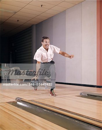 1960ER JAHRE MANN ÜBER RELEASE BALL IN ALLEY INDOOR BOWLING