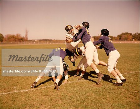 1960s SIX FOOTBALL PLAYERS RUNNING BLOCKING TACKLING ON SCRIMMAGE FIELD
