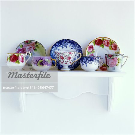 2000s FLORAL PATTERNED TEACUPS AND SAUCERS ON MANTELPIECE WHITE SHELF