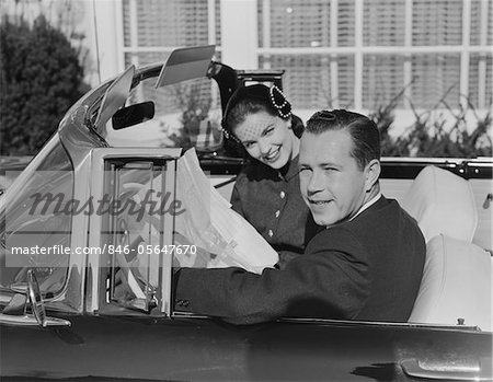 1950s HUSBAND WIFE MAN WOMAN IN AUTOMOBILE READING MAP