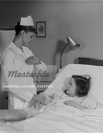 ANNÉES 1960 FEMME INFIRMIÈRE CONTRÔLE POULS PRISE TEMPÉRATURE SUR LITTLE GIRL PATIENT DANS SON LIT D'HÔPITAL