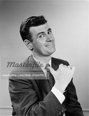 1950s BUSINESS MAN SMILING GIVING THUMBS UP SIGN POINTING TO HIMSELF