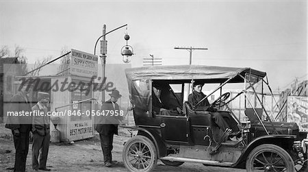 1910s KANSAS CITY MISSOURI MAN FILLING TANK OF OLD CAR AT GASOLINE STATION NEXT TO THE OLD SANTA FE TRAIL