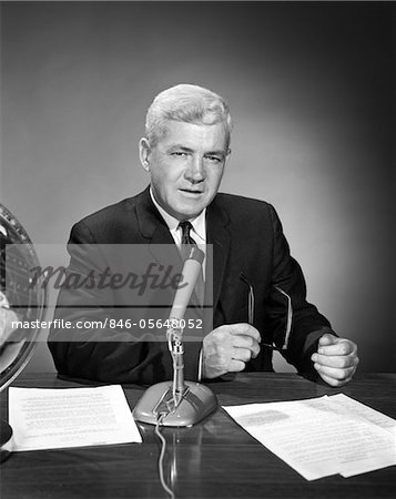 1960s MAN ANNOUNCER NEWSCASTER TALKING AT MICROPHONE INDOOR STUDIO SYMBOLIC FREEDOM OF SPEECH