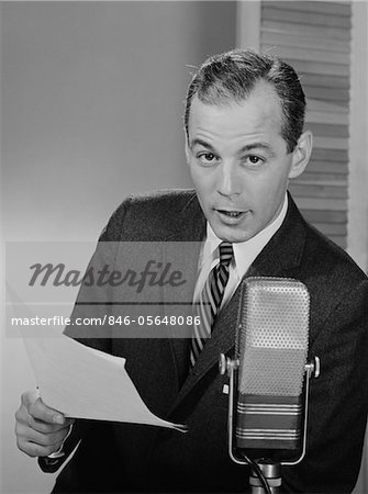 ANNÉES 1950 - ANNÉES 1960 SERIOUS MAN PARLANT DANS LE MICROPHONE HOLDING PAPIERS JOURNALISTE PRÉSENTATEUR DIFFUSEUR