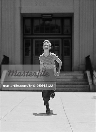 1930s - 1940s BOY RUNNING FROM SCHOOL CARRYING BOOKS