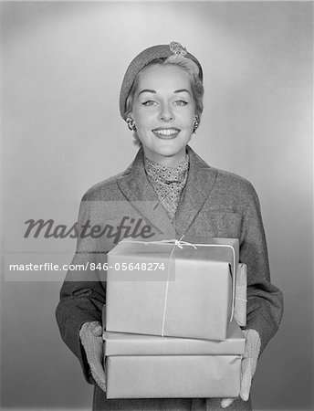 1950s FASHIONABLY DRESSED WOMAN HOLDING PACKAGES WRAPPED IN BROWN PAPER AND STRING