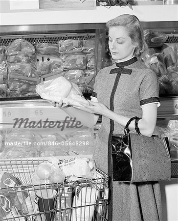 1950s - 1960s BLOND WOMAN SELECTING POULTRY IN SUPERMARKET