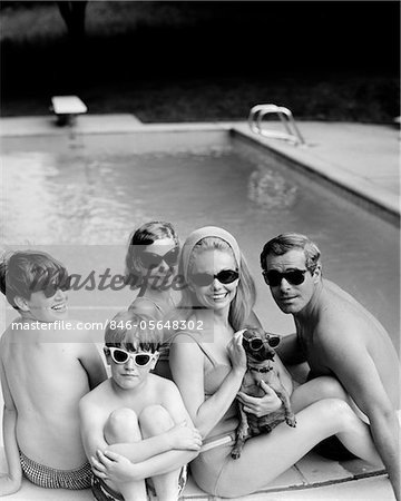 CÔTÉ PISCINE DES ANNÉES 1960 - ANNÉES 1970 FAMILLE PORTRAIT PÈRE MÈRE FILS FILLE AVEC CHIEN TECKEL TOUS PORTER DE LUNETTES DE SOLEIL