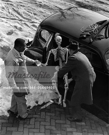 ANNÉES 1930 DEUX HOMMES PRENANT LE SQUELETTE DE LA BANQUETTE ARRIÈRE DE VOITURE EXTÉRIEUR POUR L'HIVER