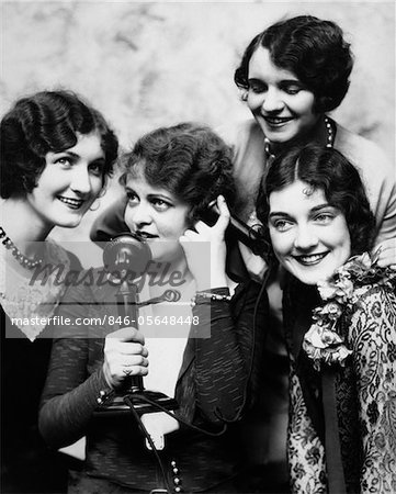 1920s GROUP OF FOUR WOMEN GATHERED AROUND CANDLESTICK PHONE