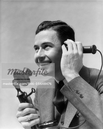 1920s - 1930s MAN TALKING ON CANDLESTICK PHONE