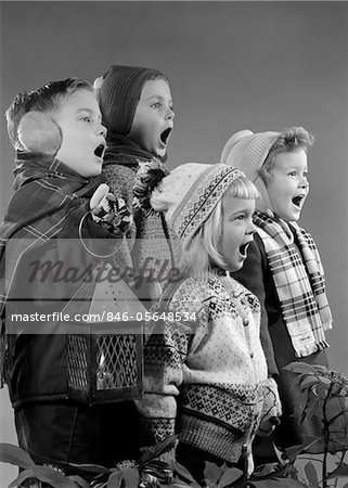 1950s FOUR CHILDREN TWO BOYS TWO GIRLS SINGING CHRISTMAS CAROL TOGETHER HOLDING CANDLE LANTERN