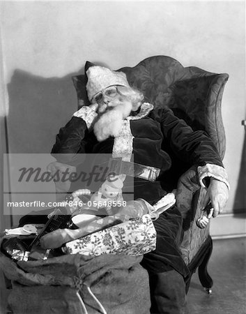 1920s - 1930s SANTA CLAUS ASLEEP IN ARMCHAIR WITH BAG SACK OF TOYS