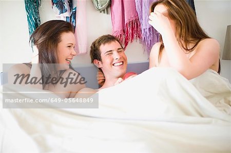 Nude teenagers in bed together