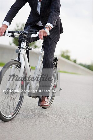 Vélo homme d'affaires dans le parc urbain