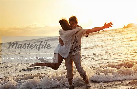 Couple playing in waves at beach