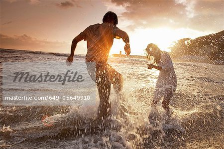 Couple jouant dans les vagues à la plage