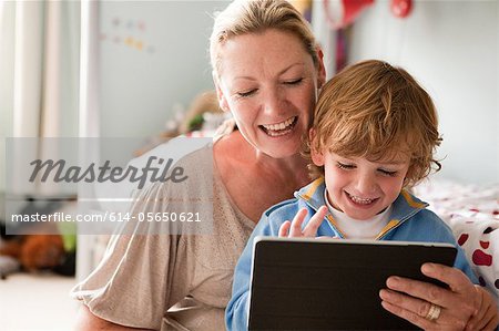 Mother using a digital tablet with her son