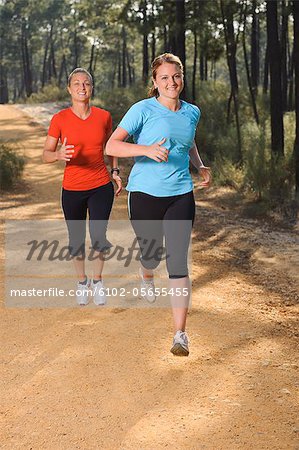 Two women jogging in forest