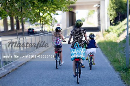 a woman and two children riding bikes