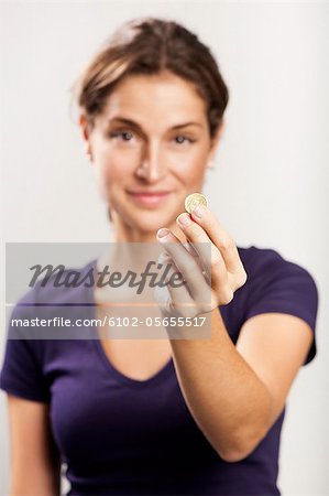 A woman holding a coin