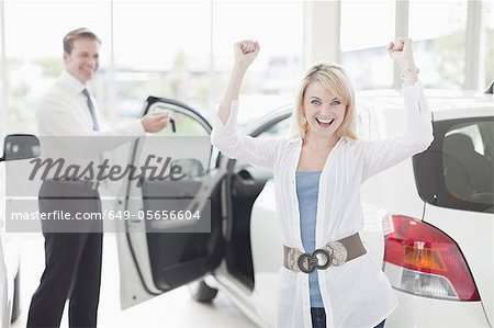 Woman cheering in car dealership