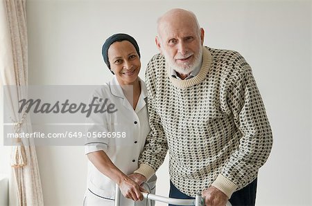 Caretaker helping older man with walker