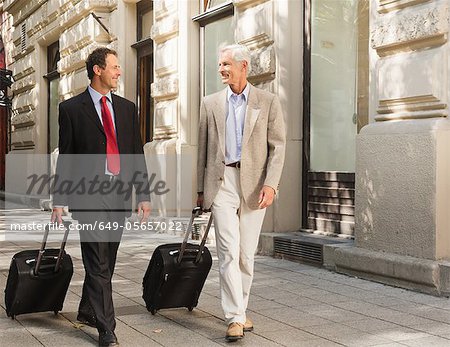 Les hommes d'affaires à l'extérieur des bagages de roulement