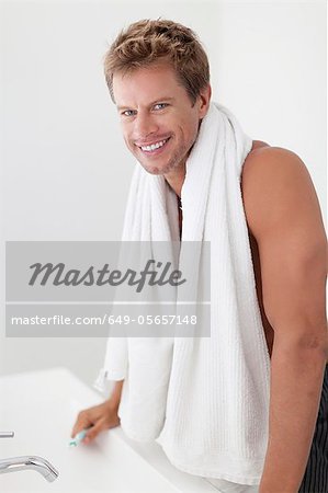 Smiling man with towel in bathroom