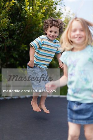 Lächelnde Kinder springen auf dem Trampolin