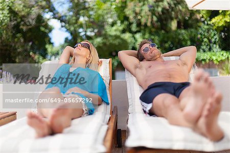 Couple relaxing in lawn chairs
