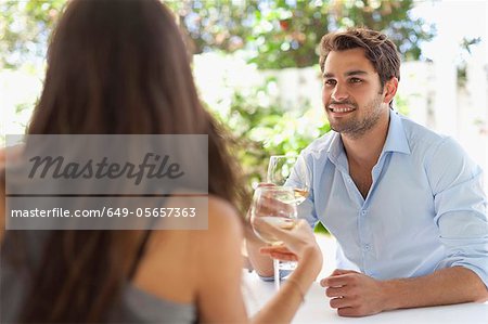 Couple ayant le vin à table à l'extérieur
