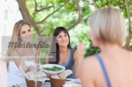 Women eating at table outdoors