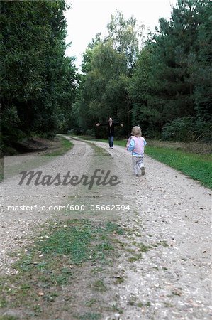 Baby Girl Running to Mother on Country Road, Farnham, England