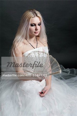 Belle jeune fille en robe blanche sur fond noir