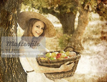 Beautiful redhead girl with fruits in basket at garden.