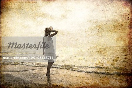 Girl at sea coast. Photo in old image style.