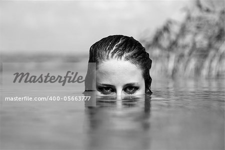 Girl in the river. Photo in noisy black and white style.