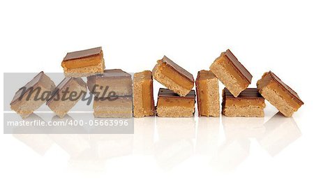 Chocolate and caramel candy squares in random formation isolated over white background.