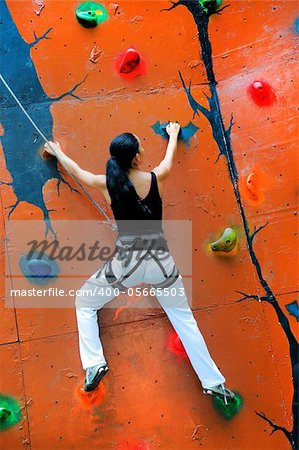 girl climbing on a climbing wall training in insurance