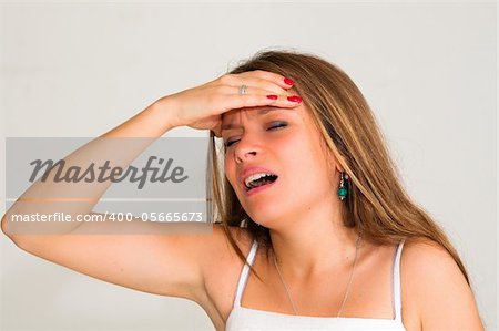 young woman with headache holding her hand to the head
