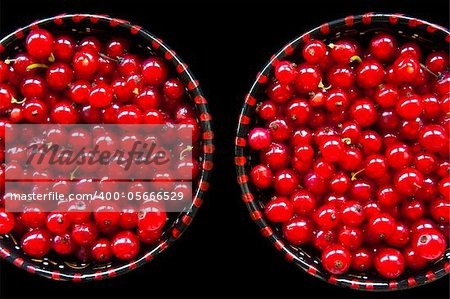 Two bowls of red currant isolated on black