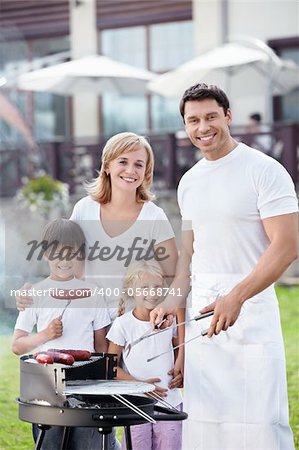 Families with children with barbecue outdoors
